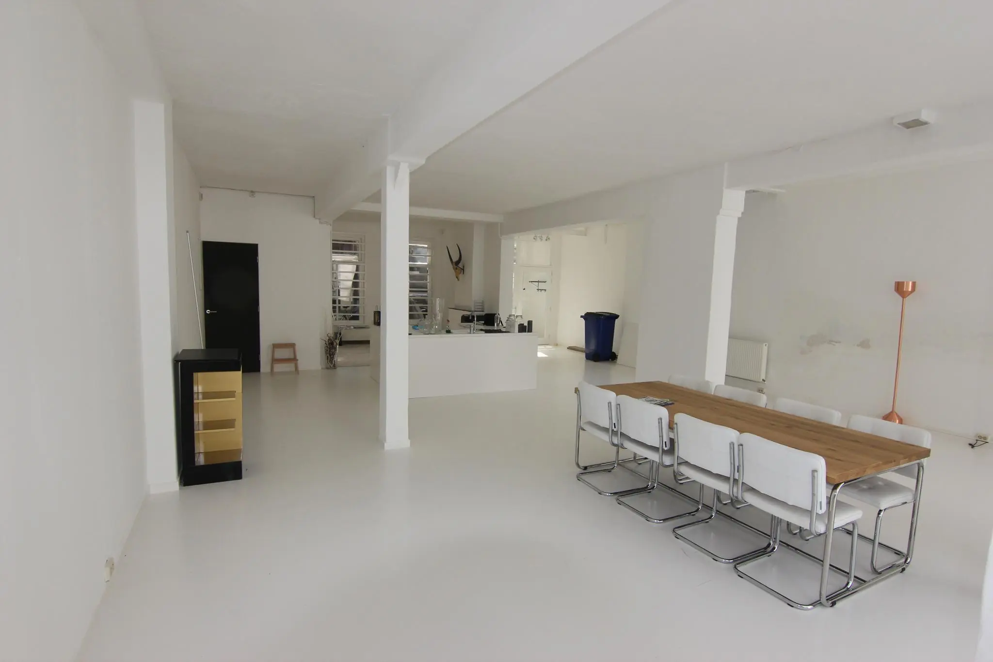 Ruim, modern wit interieur aan de Graaf Florisstraat met een houten eettafel, minimalistische keuken en strakke inrichting.